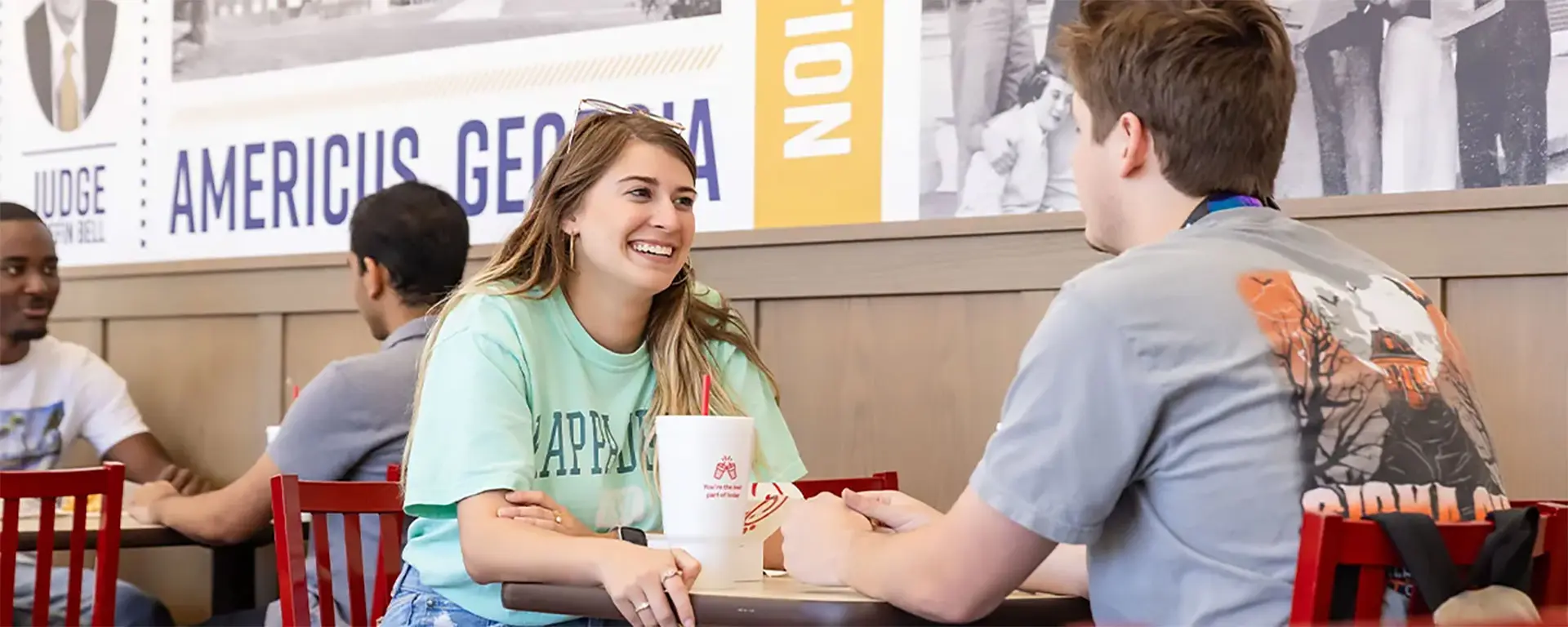 Students enjoying a meal and conversation at table